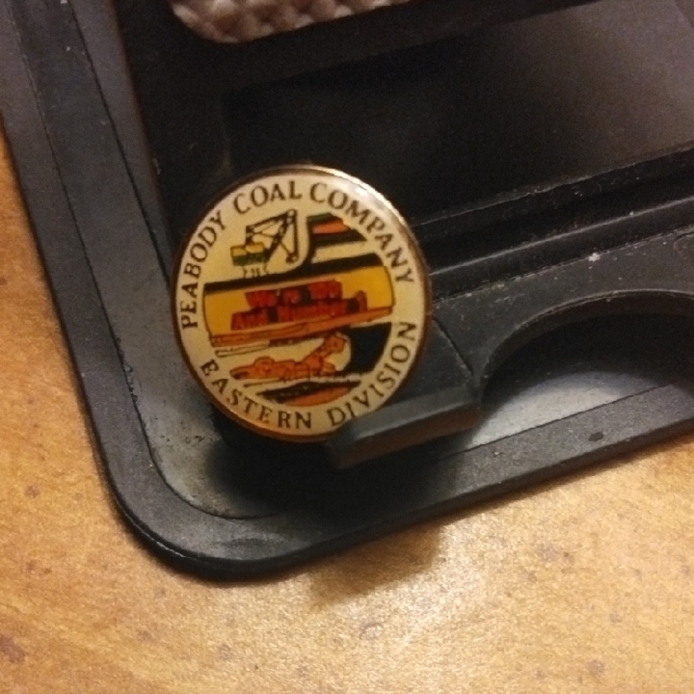 Gold Circular Jewelry Pin with Emblem Design